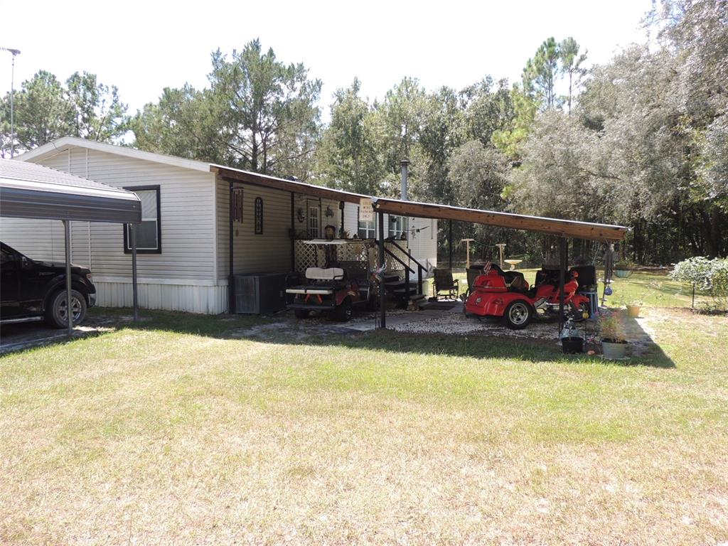 7050 Southeast Co Road 337 Morriston, FL 32668 - Photo 10 of 67 a view of a patio with a table and chairs a barbeque with wooden fence