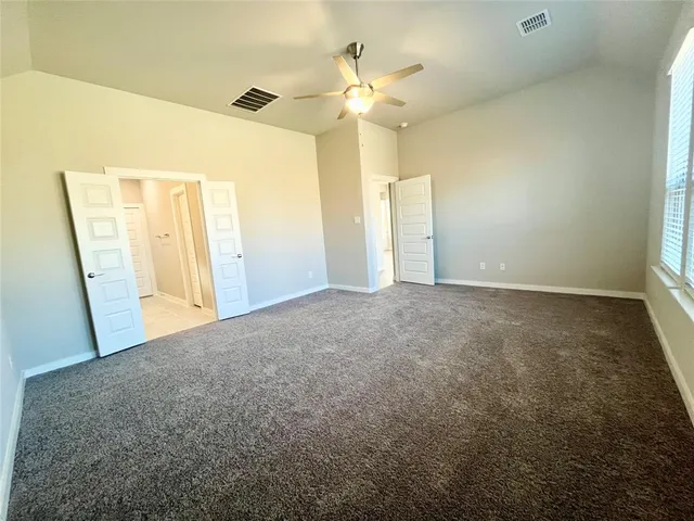 a view of a big room with windows and chandelier fan