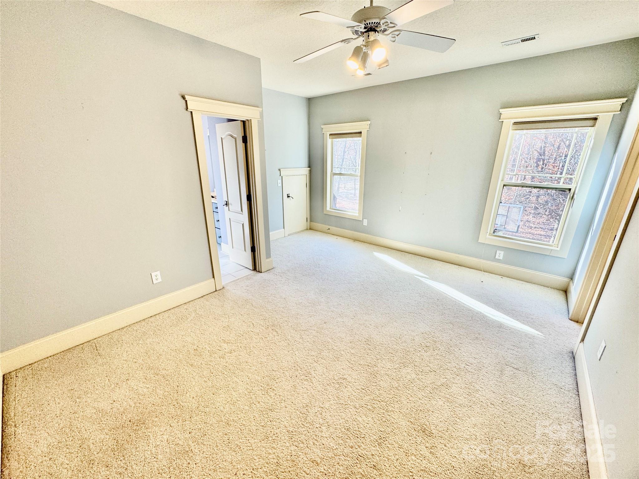 600 Baron Road Waxhaw, NC 28173 - Photo 36 of 42 an empty room with a chandelier fan and windows