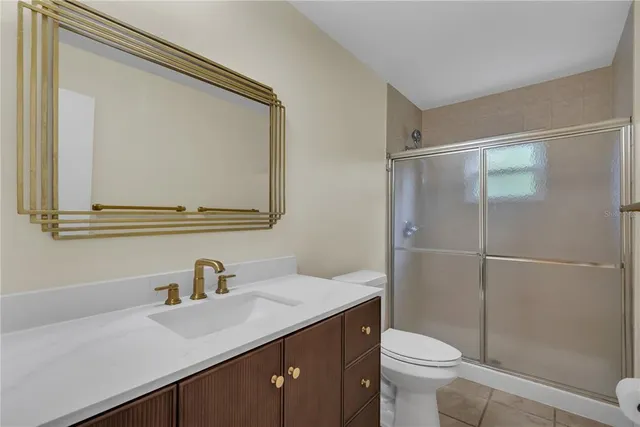 a bathroom with a sink a toilet a mirror and shower