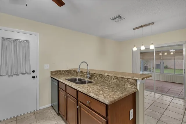 a kitchen with a granite countertop sink and white cabinets