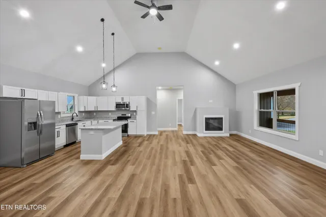 a view of an empty room with a window and fireplace