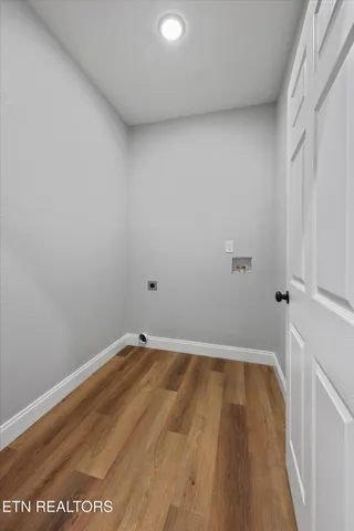 an empty room with chandelier fan and windows