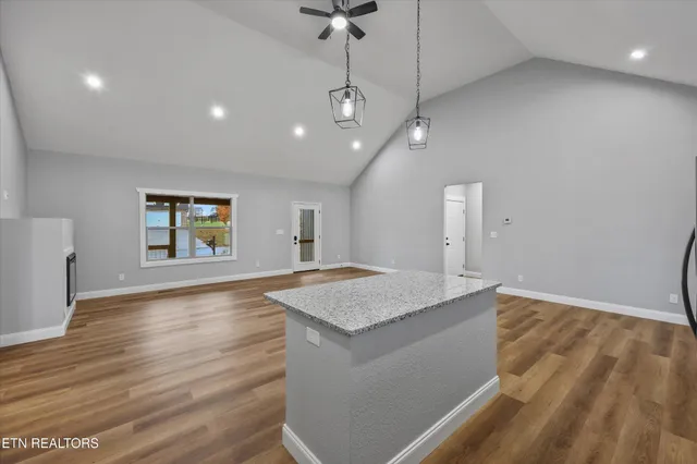 a large kitchen with kitchen island a stove a sink dishwasher and a refrigerator with wooden floor