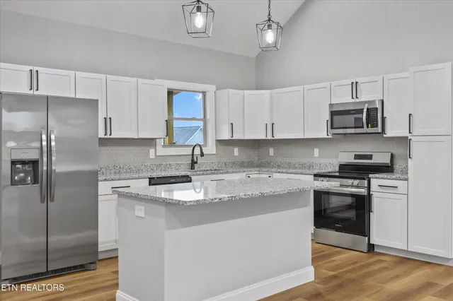a kitchen with stainless steel appliances granite countertop a sink stove and microwave
