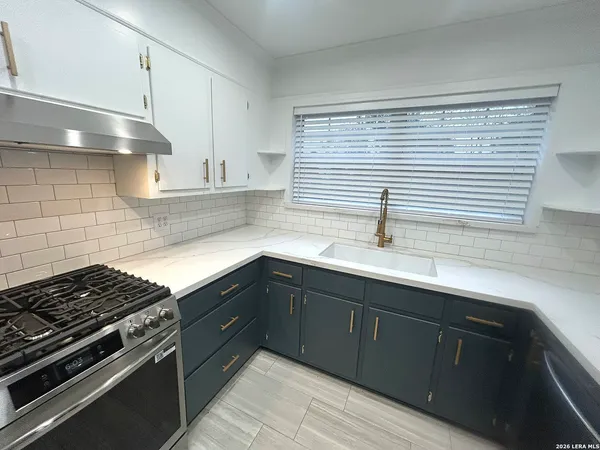 a kitchen with stainless steel appliances a sink stove and cabinets