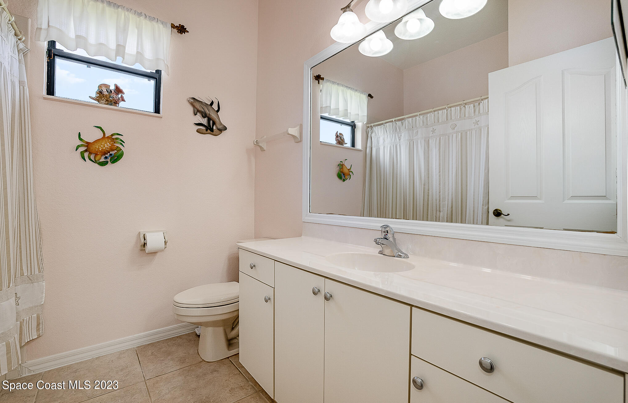 4105 Sand Ridge Drive Merritt Island, FL 32953 - Photo 19 of 31 a bathroom with a granite countertop sink a toilet and mirror