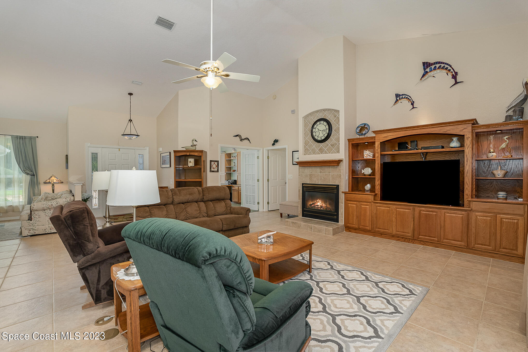 4105 Sand Ridge Drive Merritt Island, FL 32953 - Photo 7 of 31 a living room with furniture a flat screen tv and a fireplace