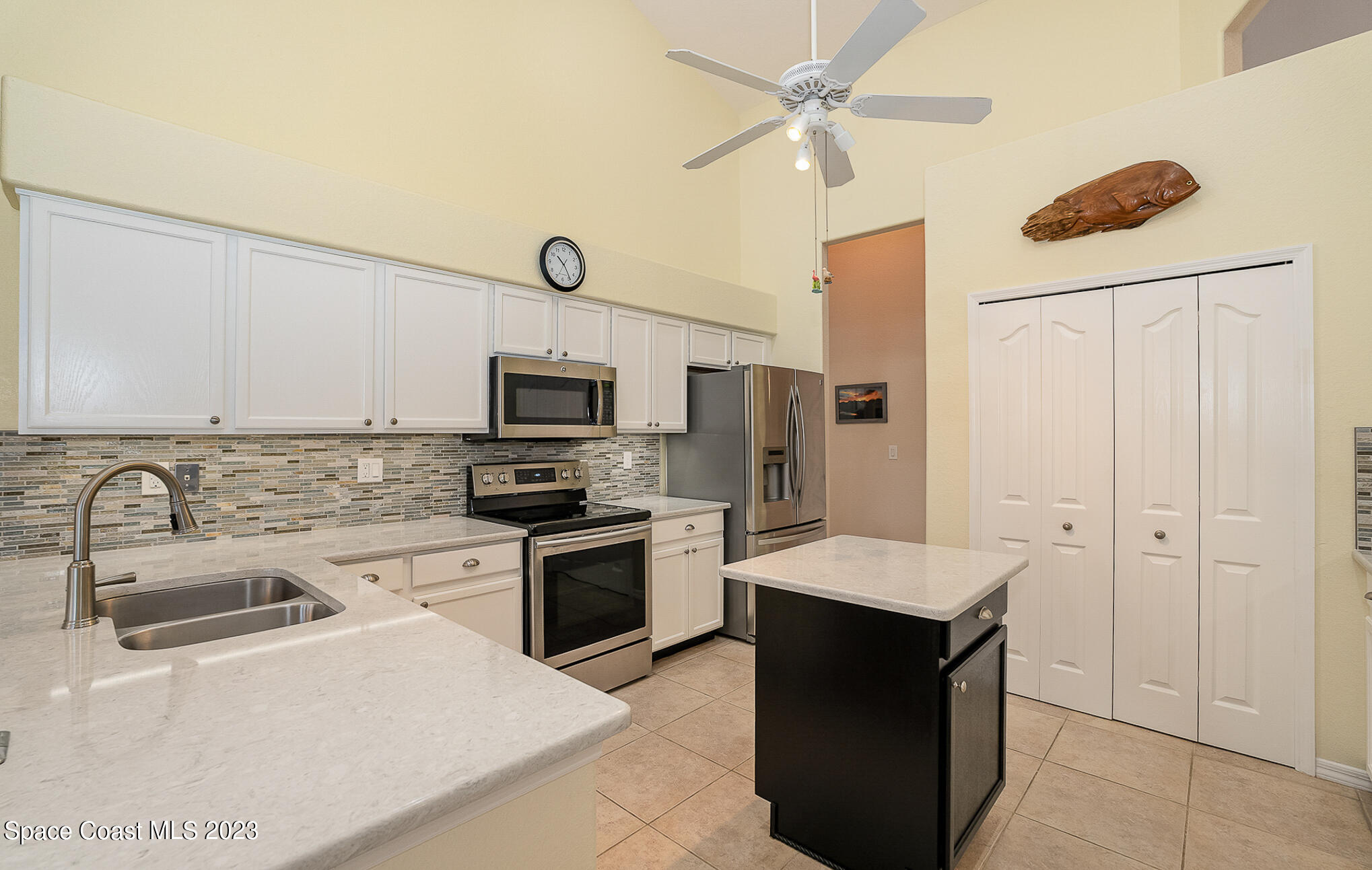 4105 Sand Ridge Drive Merritt Island, FL 32953 - Photo 8 of 31 a kitchen with stainless steel appliances granite countertop a refrigerator a stove a sink and white cabinets