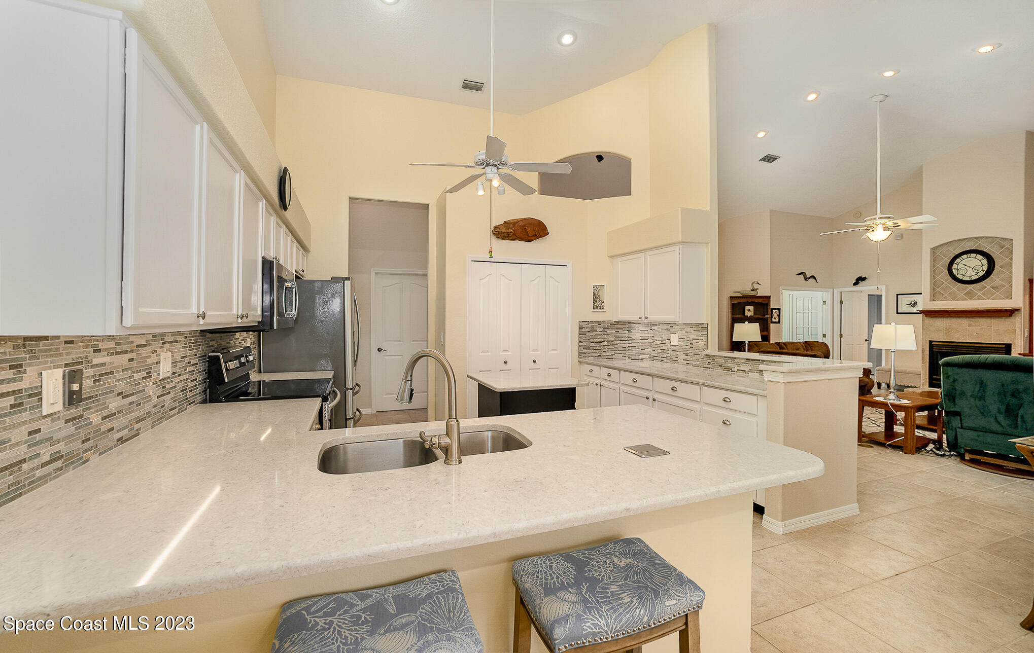 4105 Sand Ridge Drive Merritt Island, FL 32953 - Photo 10 of 31 a kitchen with a sink a stove and chairs