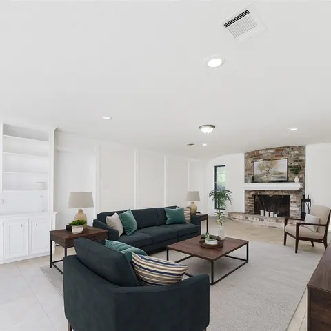 a living room with furniture a flat screen tv and kitchen view