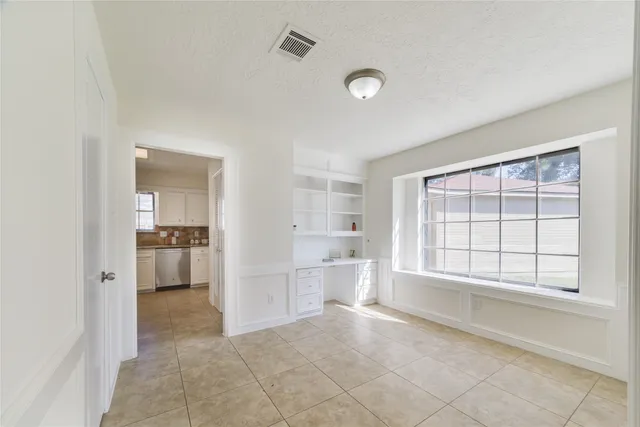 a view of an empty room and a kitchen