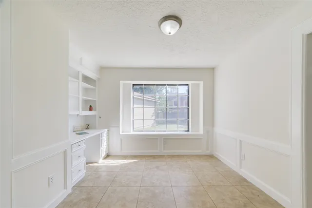 a view of a kitchen with white cabinets and a window