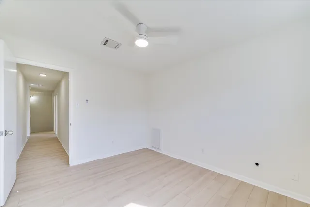 an empty room with wooden floor and mirror