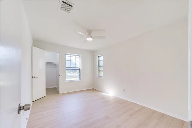 an empty room with wooden floor and window