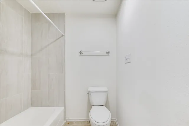 a bathroom with a toilet and a shower curtain