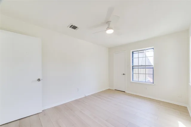 an empty room with windows and closet