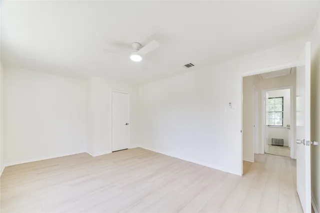 a view of a room with wooden floor and a bathroom