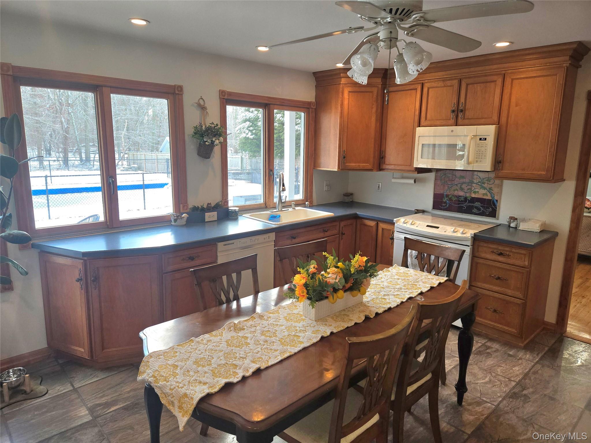 22 Rustic Road Yaphank, NY 11980 - Photo 6 of 35 Kitchen with brown cabinetry, white appliances, recessed lighting, and a ceiling fan