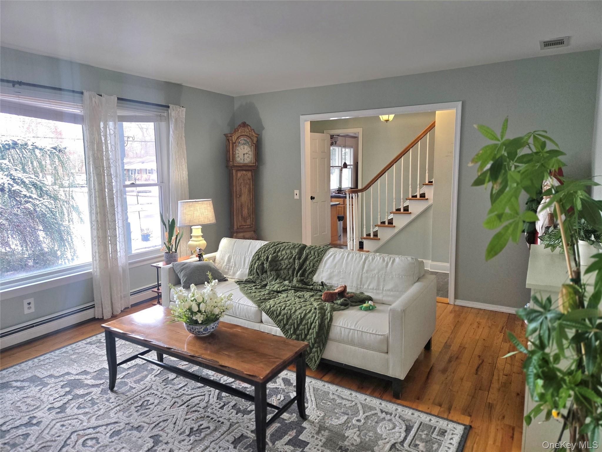 22 Rustic Road Yaphank, NY 11980 - Photo 9 of 35 Living room featuring hardwood / wood-style floors, stairs, and a baseboard radiator