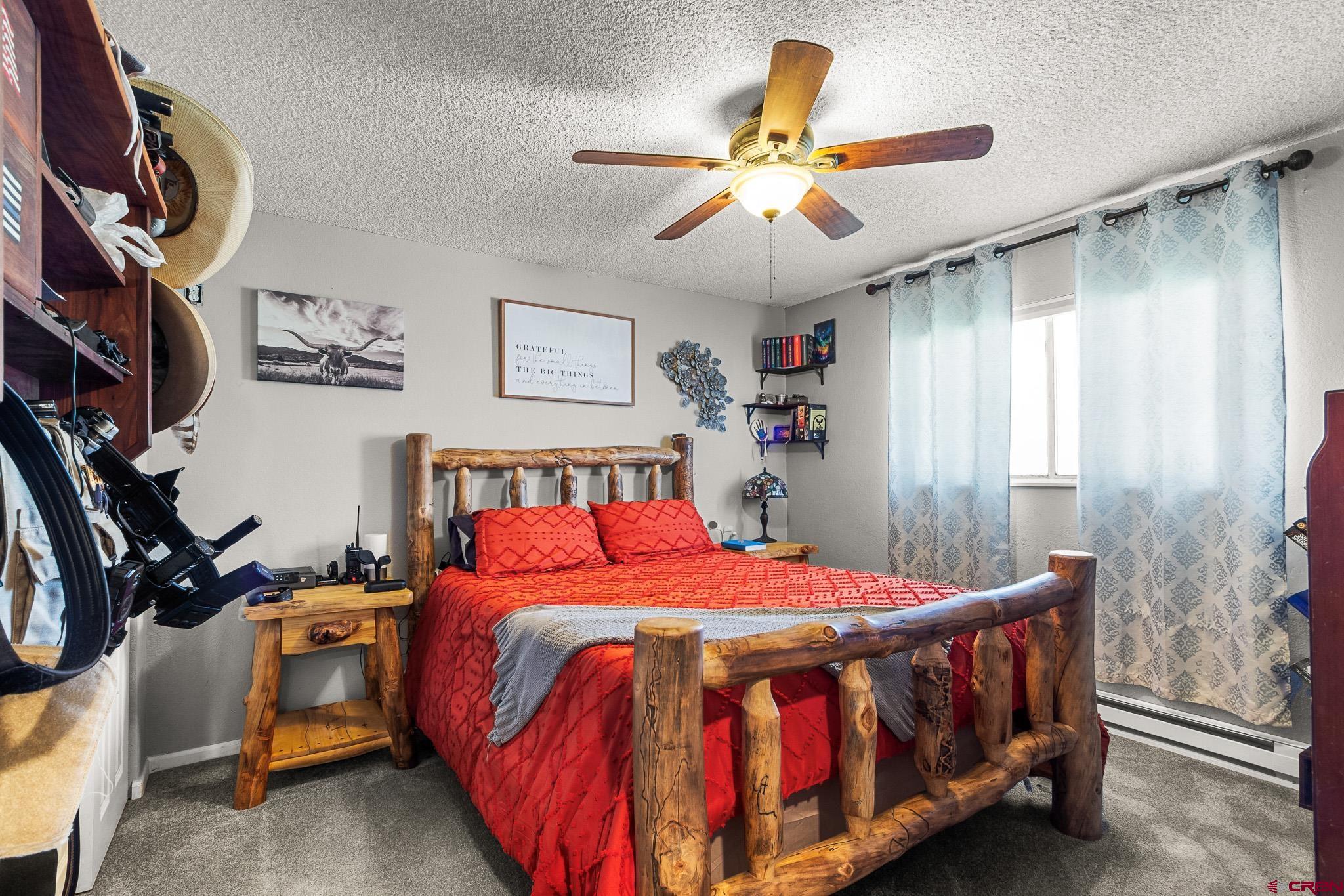 13330 L Road Montrose, CO 81401 - Photo 11 of 19 a bedroom with a bed and a chandelier