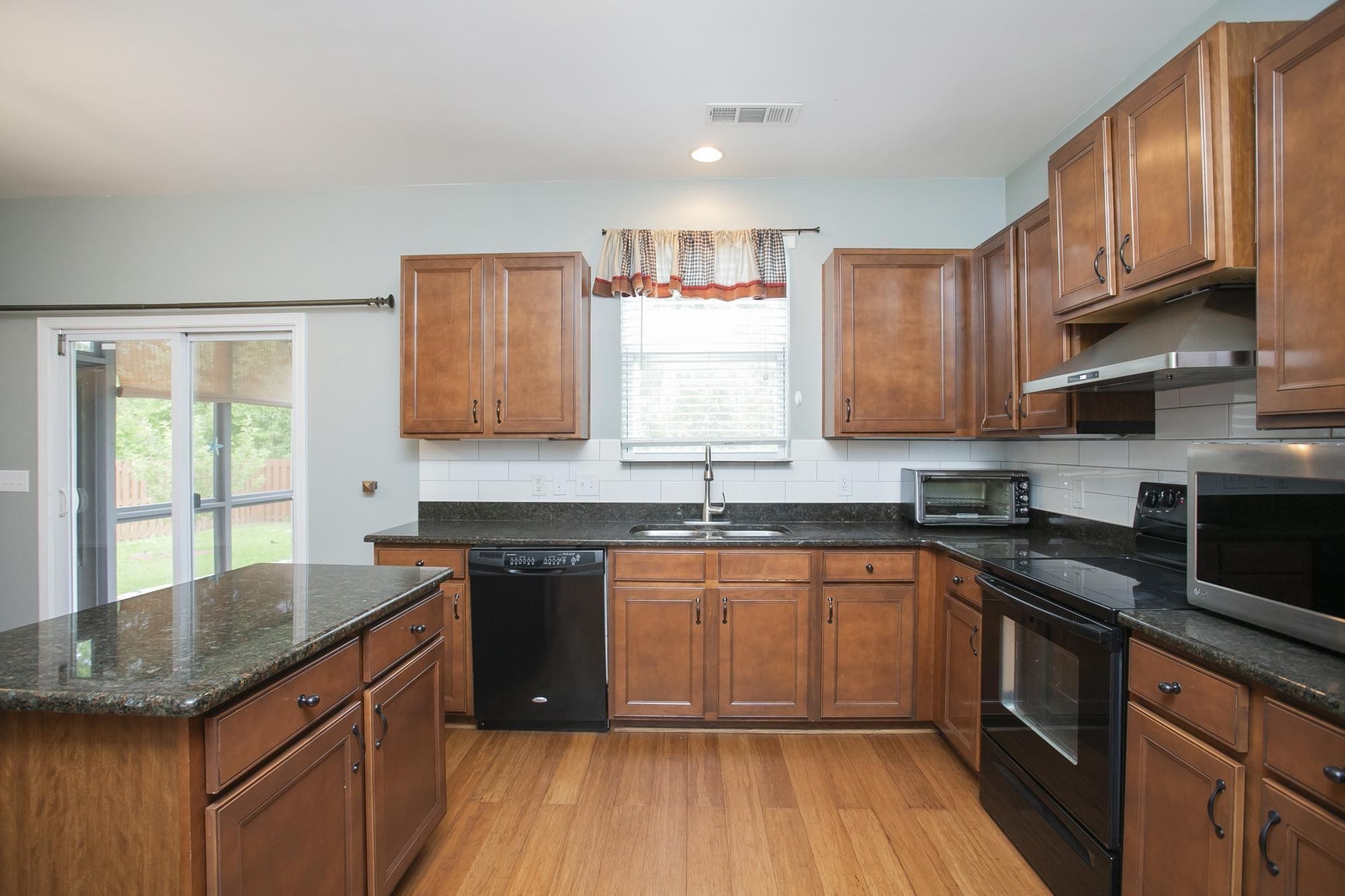 3601 Harpeth Springs Drive Nashville, TN 37221 - Photo 13 of 55 a kitchen with granite countertop wooden cabinets stainless steel appliances a sink and a window