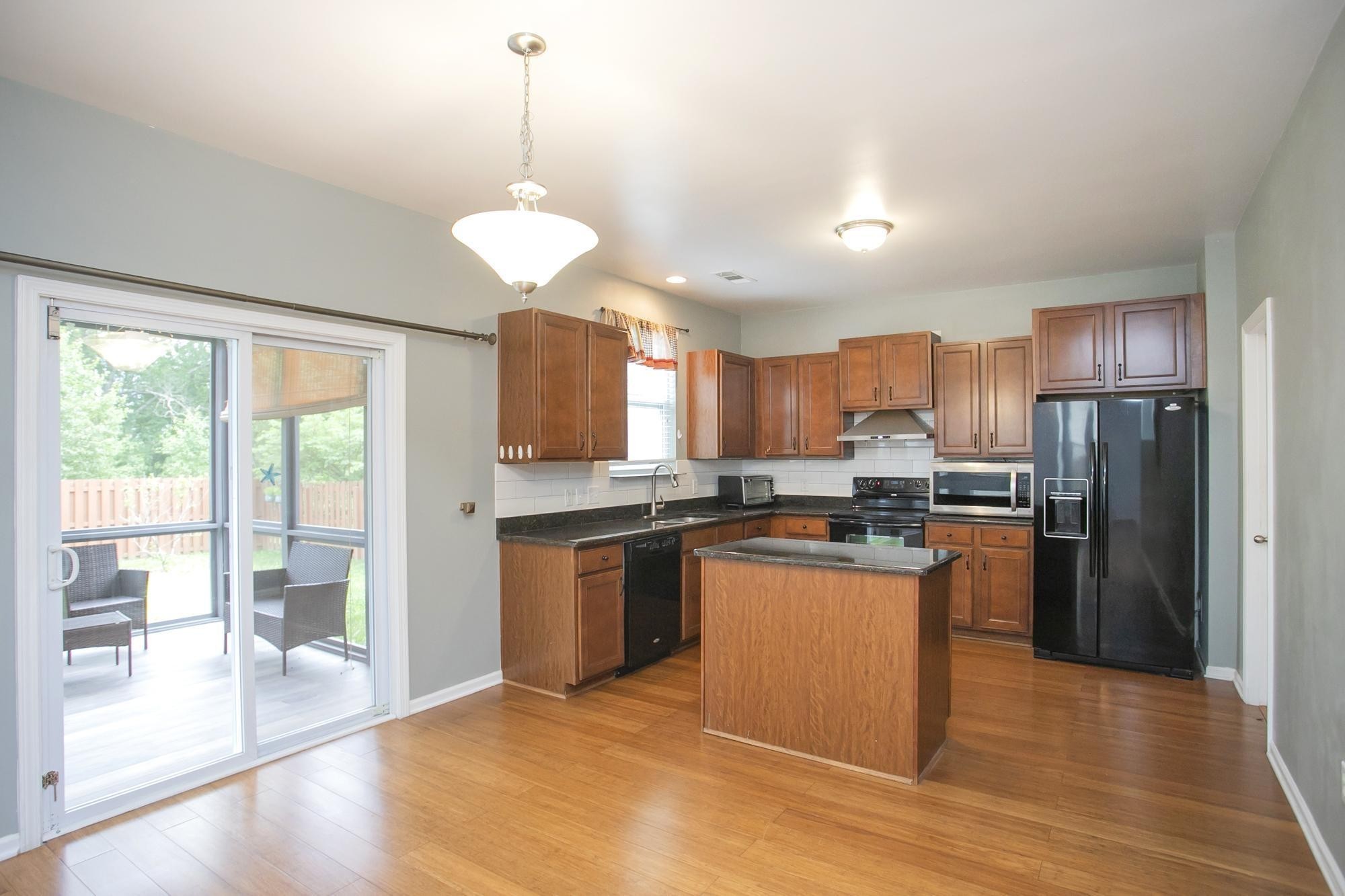 3601 Harpeth Springs Drive Nashville, TN 37221 - Photo 15 of 55 a kitchen with stainless steel appliances granite countertop a refrigerator a sink dishwasher a stove and a dining table with wooden floor