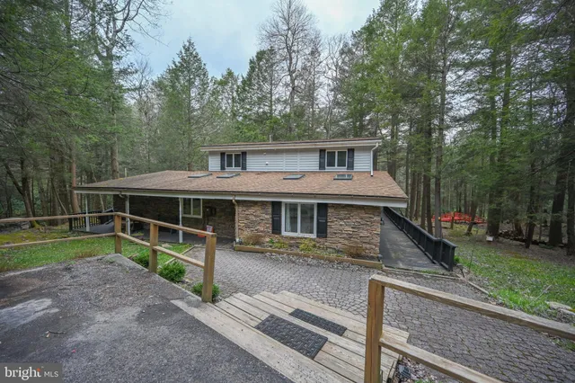 a view of a house with backyard and trees