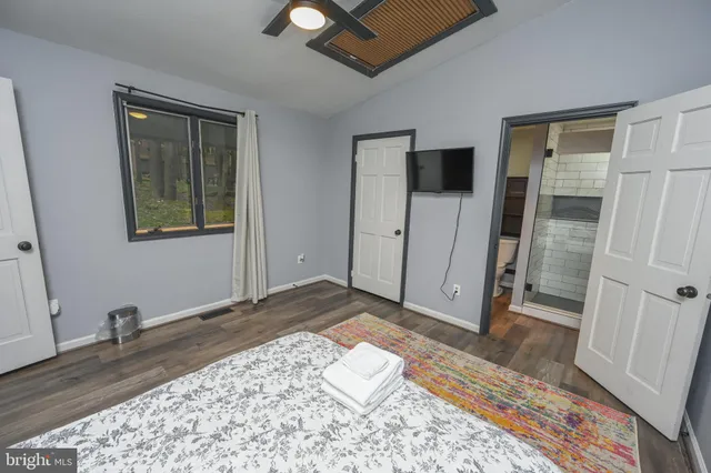 a view of a bedroom with wooden floor and bathroom