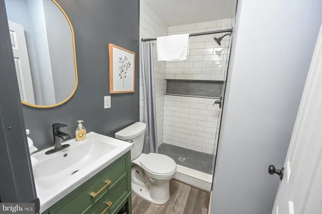 a view of a hallway with wooden floor and cabinet