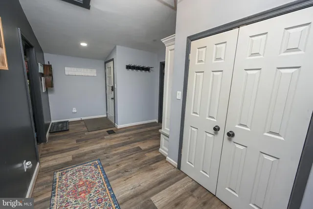 a view of a hallway with wooden floor and entryway