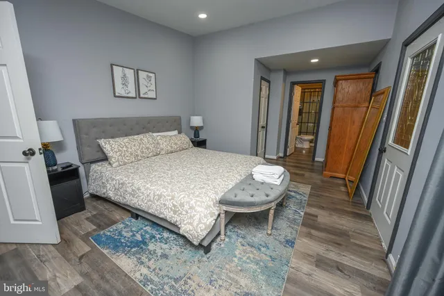 a bedroom with bed and wooden floor