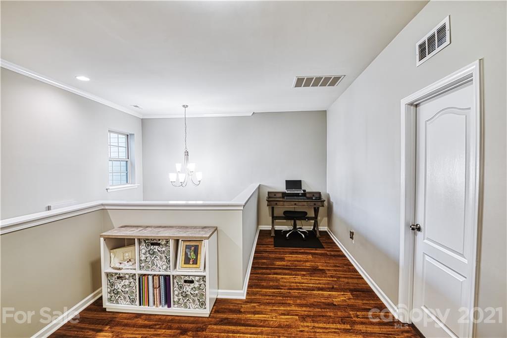 606 Amber Meadows Way Tega Cay, SC 29708 - Photo 11 of 23 a view of a hallway with wooden floor and staircase