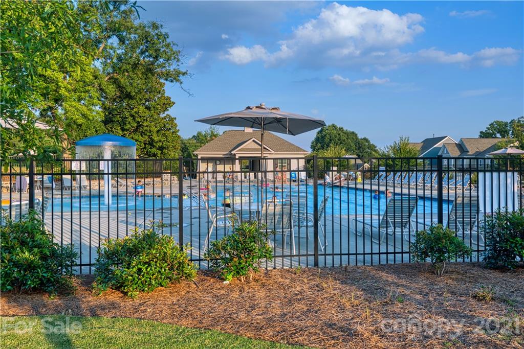 606 Amber Meadows Way Tega Cay, SC 29708 - Photo 20 of 23 a view of a brick house with a flower garden in the background