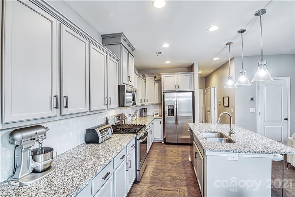 606 Amber Meadows Way Tega Cay, SC 29708 - Photo 3 of 23 a kitchen with stainless steel appliances granite countertop a sink stove and refrigerator