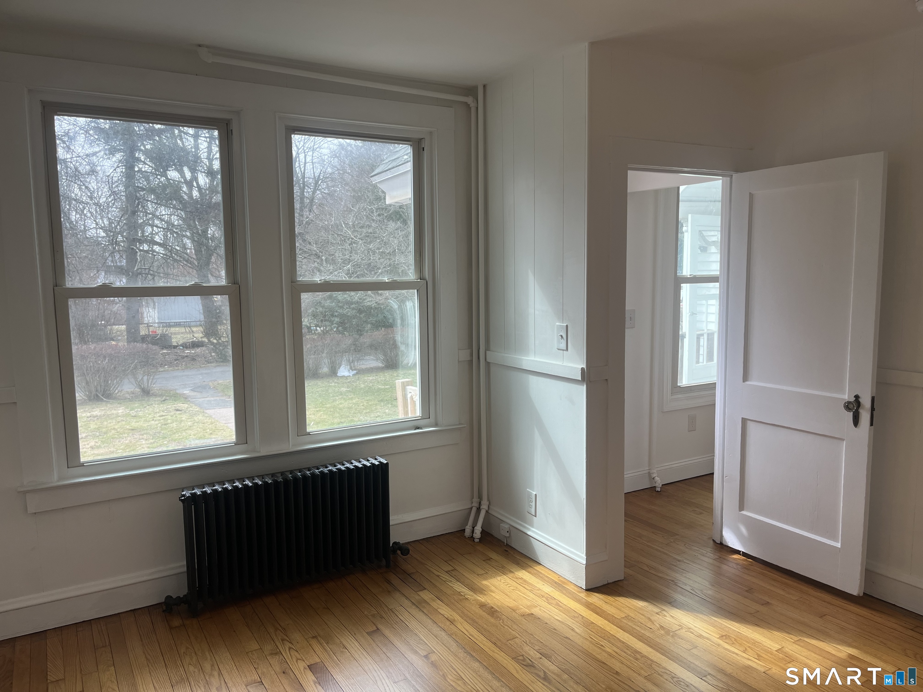 156 Union Street, Unit 2 Manchester, CT 06042 - Photo 13 of 16 an empty room with wooden floor and windows