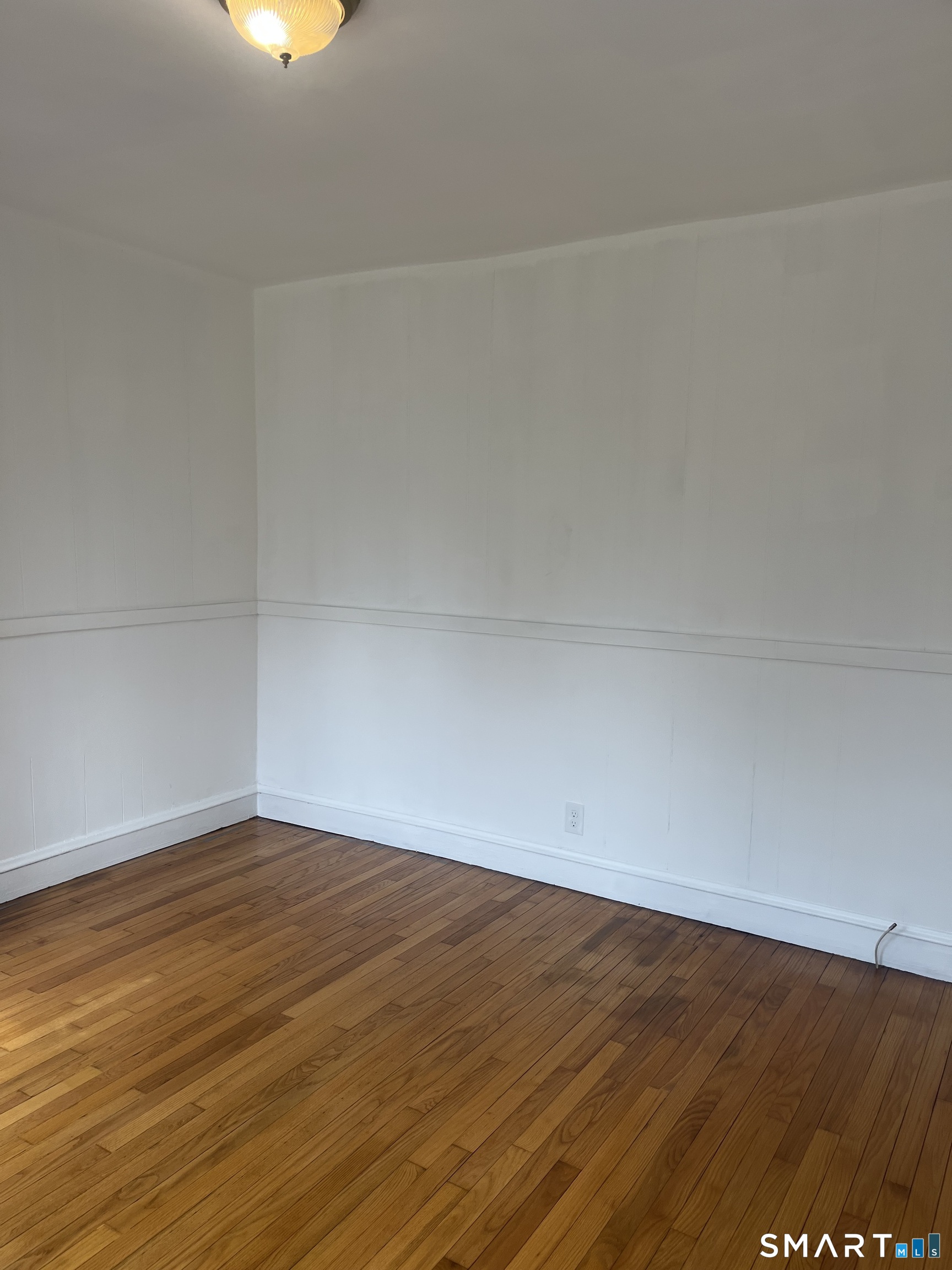156 Union Street, Unit 2 Manchester, CT 06042 - Photo 15 of 16 a view of an empty room with wooden floor and a window