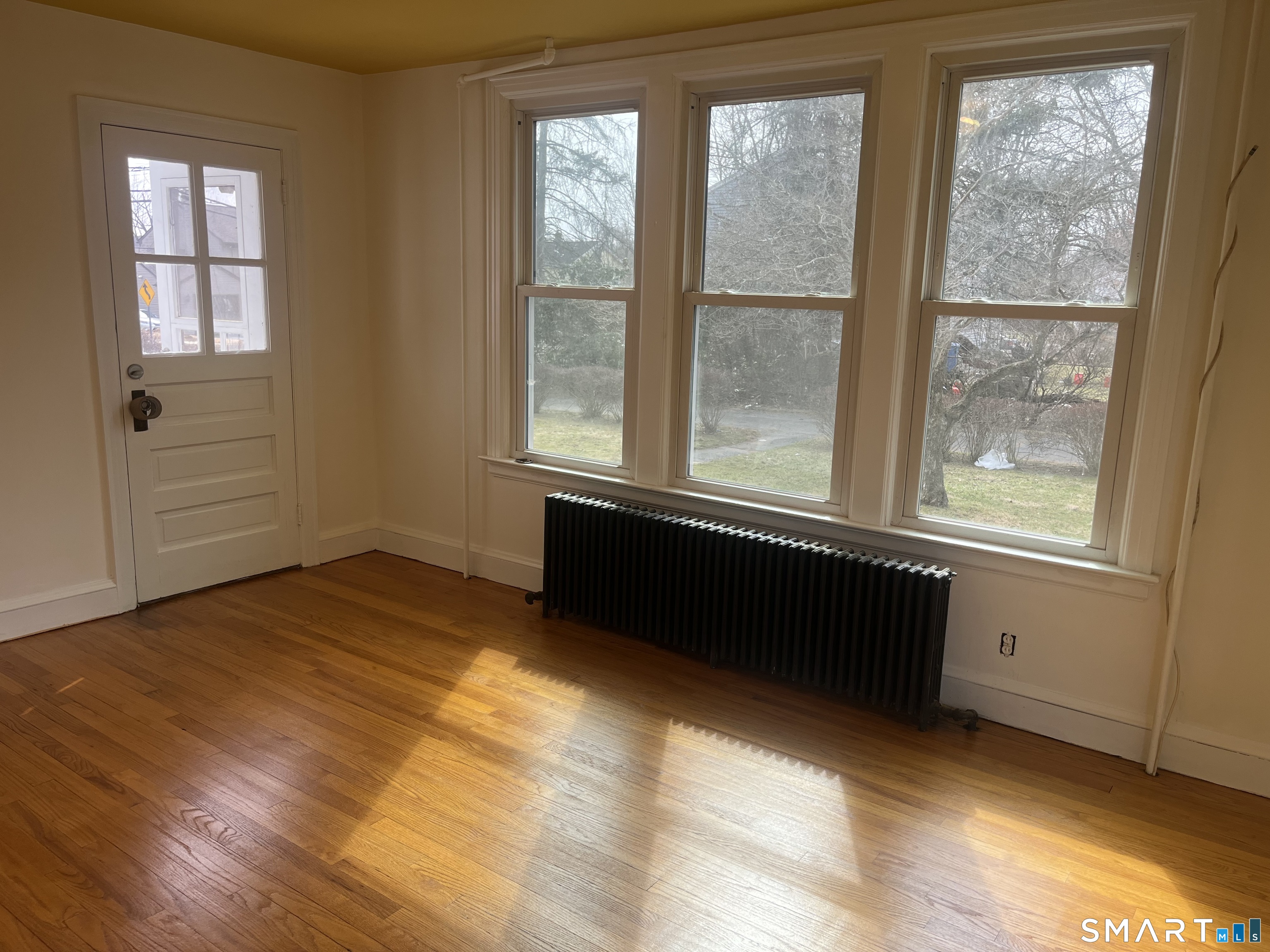 156 Union Street, Unit 2 Manchester, CT 06042 - Photo 8 of 16 a view of an empty room with wooden floor and a window