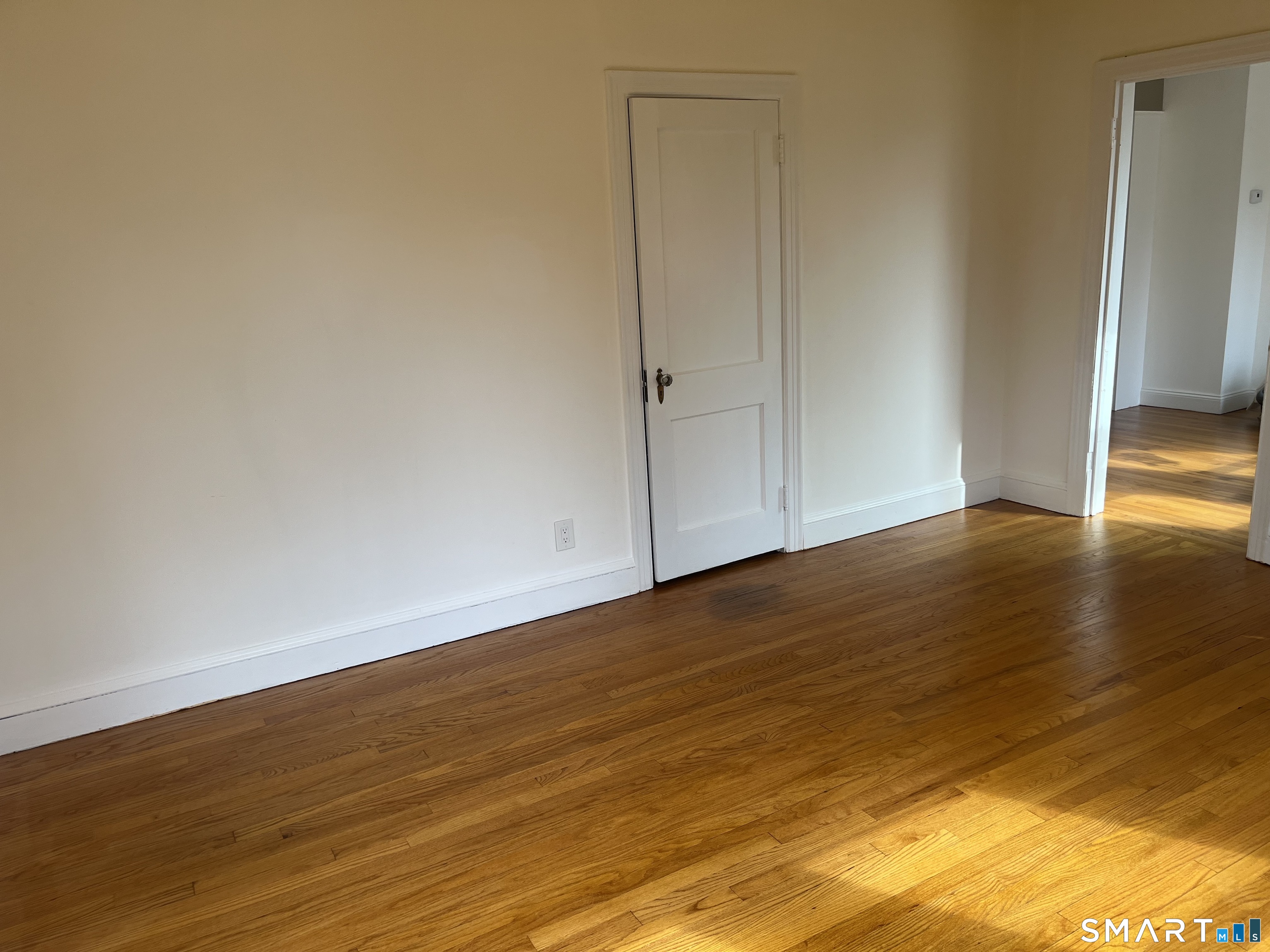 156 Union Street, Unit 2 Manchester, CT 06042 - Photo 9 of 16 a view of an empty room with wooden floor and a window