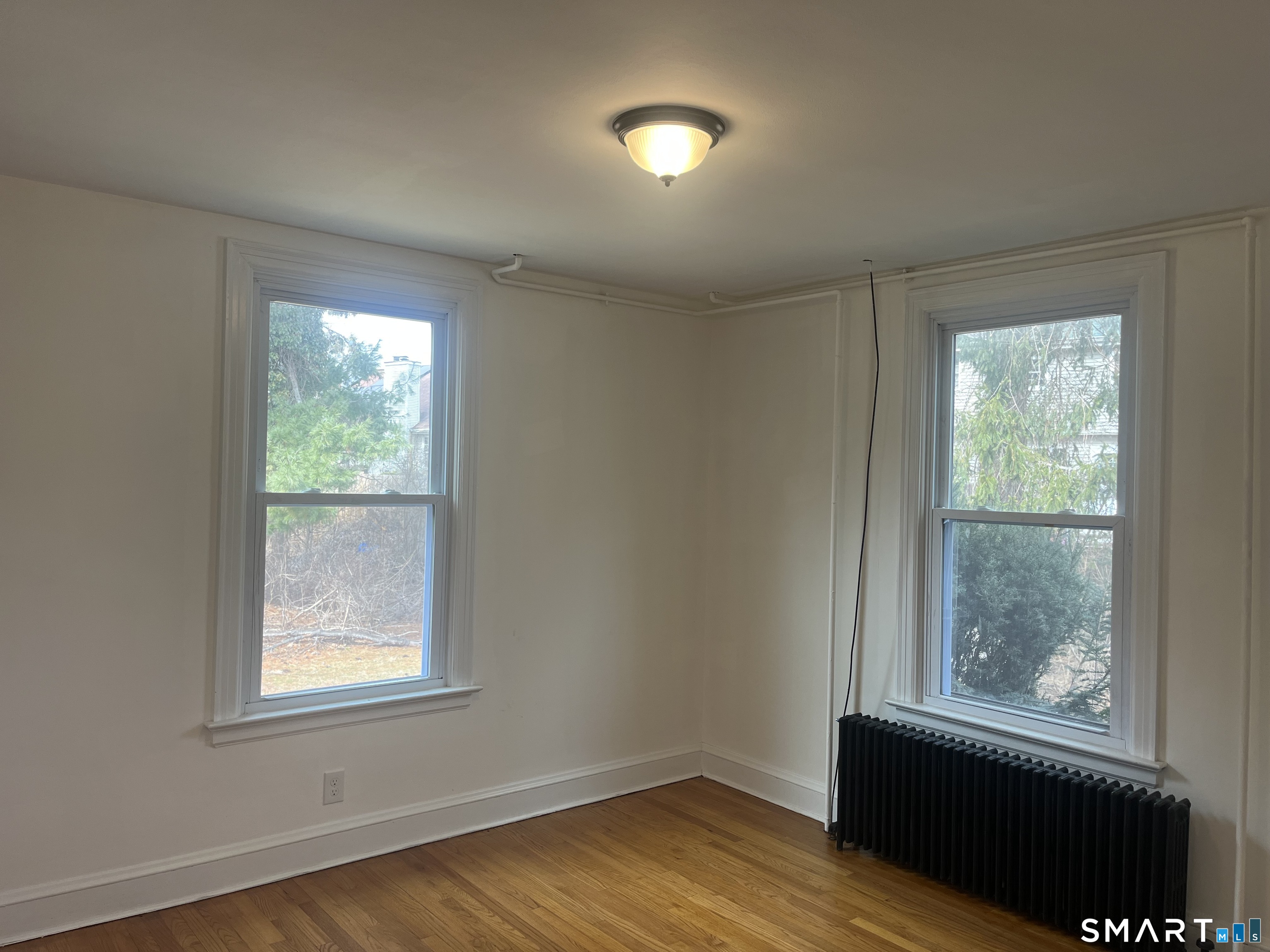 156 Union Street, Unit 2 Manchester, CT 06042 - Photo 10 of 16 an empty room with wooden floor and windows
