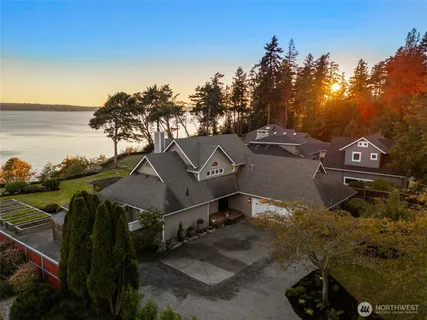 an aerial view of a house with a yard and lake view
