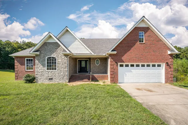 a front view of house with yard and garage
