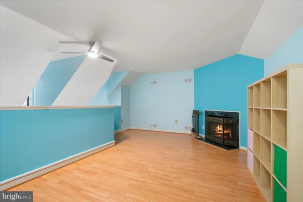 a view of empty room with wooden floor and fireplace