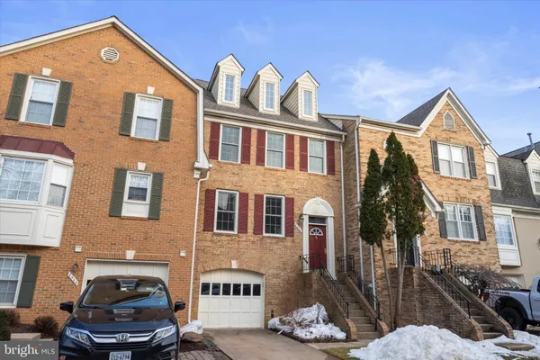 a front view of a house with cars parked