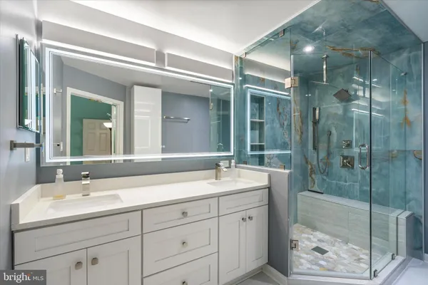 a bathroom with a shower sink and mirror