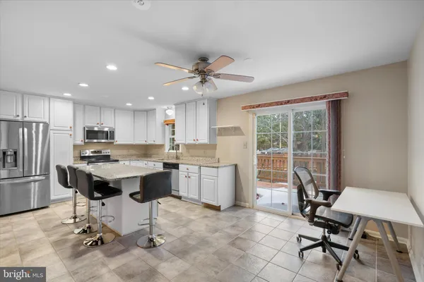 a kitchen with a table chairs refrigerator and chairs