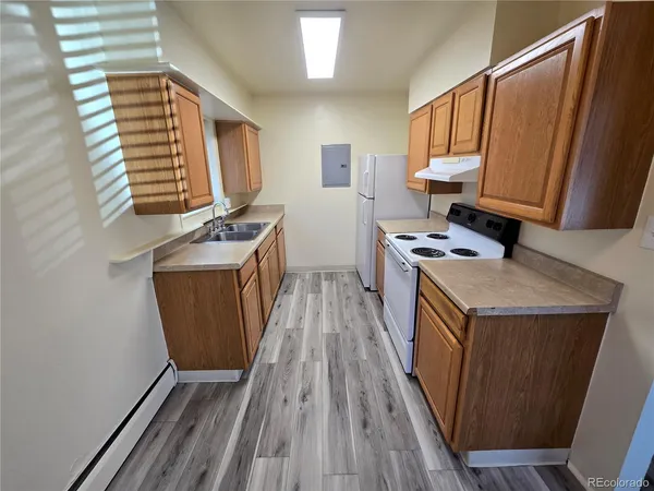 a view of a kitchen with wooden floor and electronic appliances