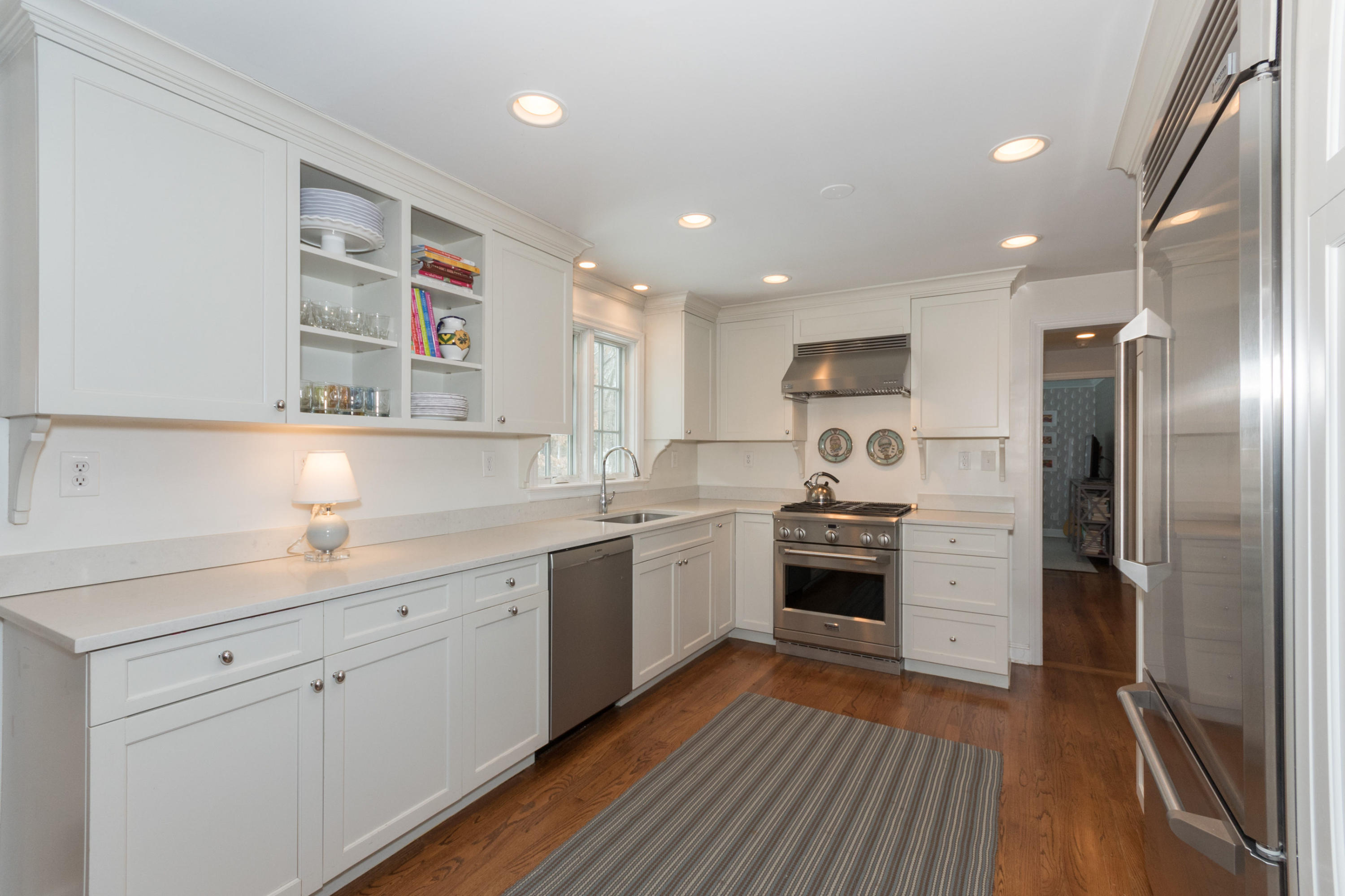 183 Smith Ridge Road New Canaan, CT 06840 - Photo 9 of 30 a kitchen with stainless steel appliances granite countertop a refrigerator a sink dishwasher a stove and white countertops with wooden floor