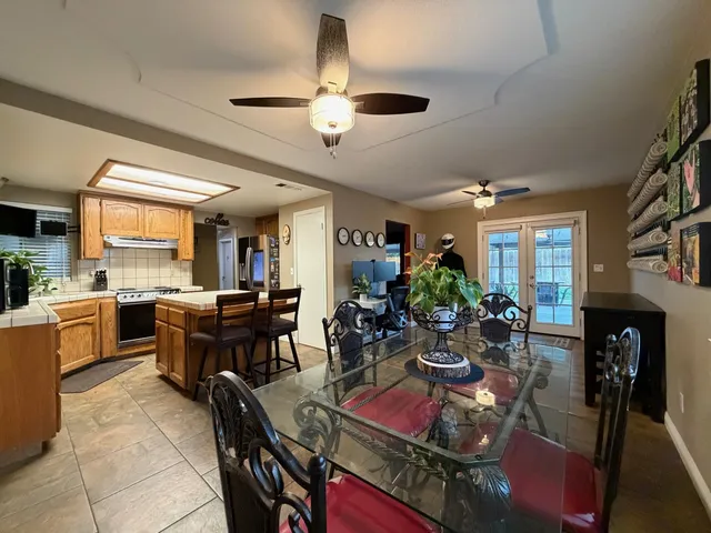 a kitchen with a dining table chairs stainless steel appliances and cabinets