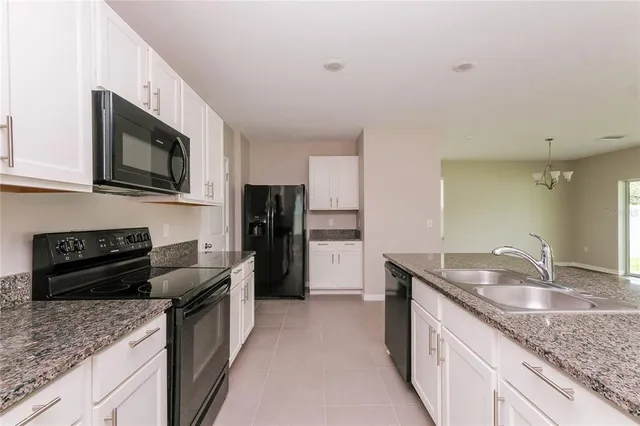 a kitchen with granite countertop stainless steel appliances a sink stove and refrigerator